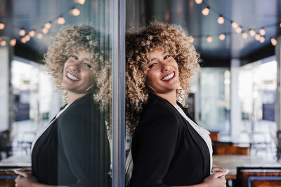 Portrait of beautiful smiling business woman leaning on glass in cafe. business concept