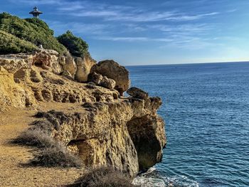 Rock formation in sea against sky