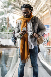 Businessman using phone while standing in airport