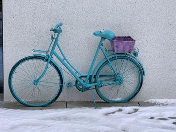 Bicycle parked on snow covered wall