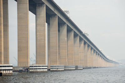 Low angle view of bridge over sea against sky