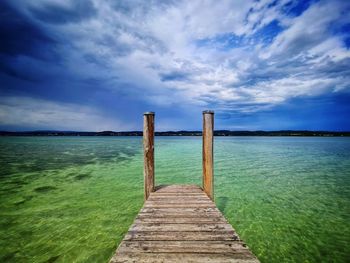 Wooden pier over sea against sky