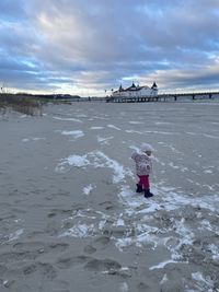 People on shore against sky