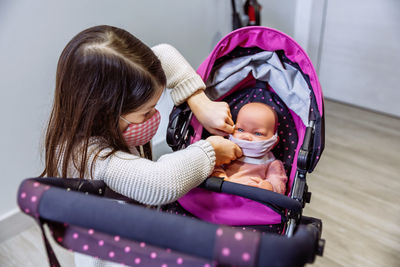 Girl playing with doll at home