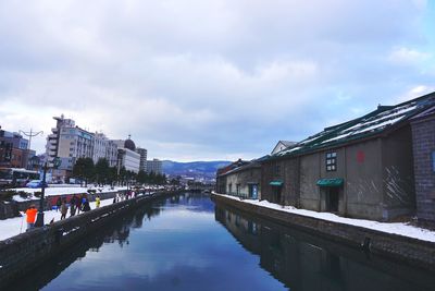 Canal amidst buildings against sky