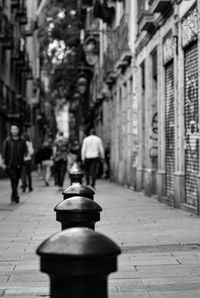 Man walking on footpath by street in city