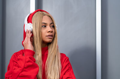 Cheerful african american woman with long blonde hair wearing sportswear and wearing headphones