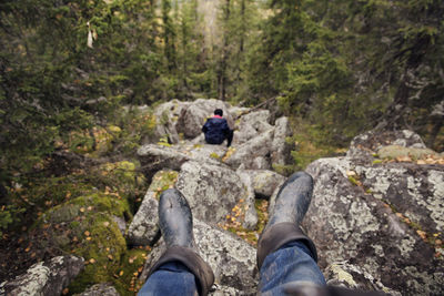 Hiker sitting on rocks in forest