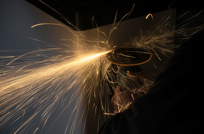 Cutting a piece of sheet with a grinding machine while sparks