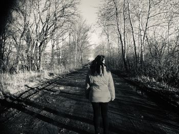 Rear view of woman walking in forest