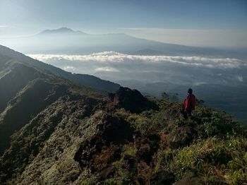 Man looking at mountains against sky