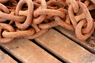 High angle view of rusty metallic chain on wooden table