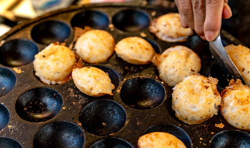 Mortar-toasted pastry or kanom krok is thai traditional dessert. woman hand removing kanom krok.