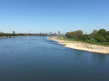 Scenic view of river against clear blue sky