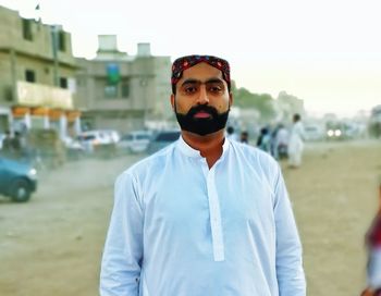 Portrait of young man standing in city