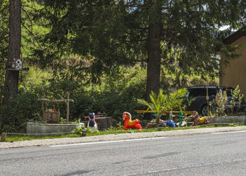 People on road by trees in city