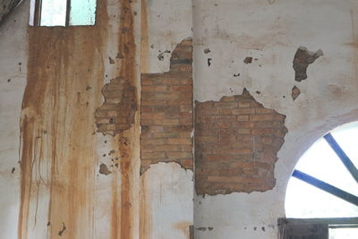 Low angle view of weathered wall in old building