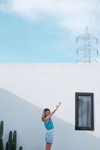 Full length of woman standing against sky