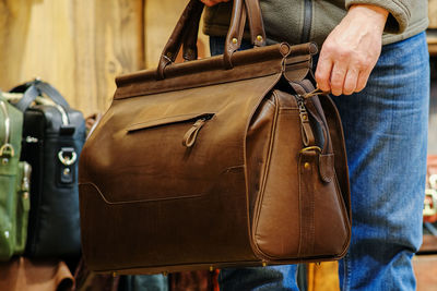 Midsection of man with bag at market stall