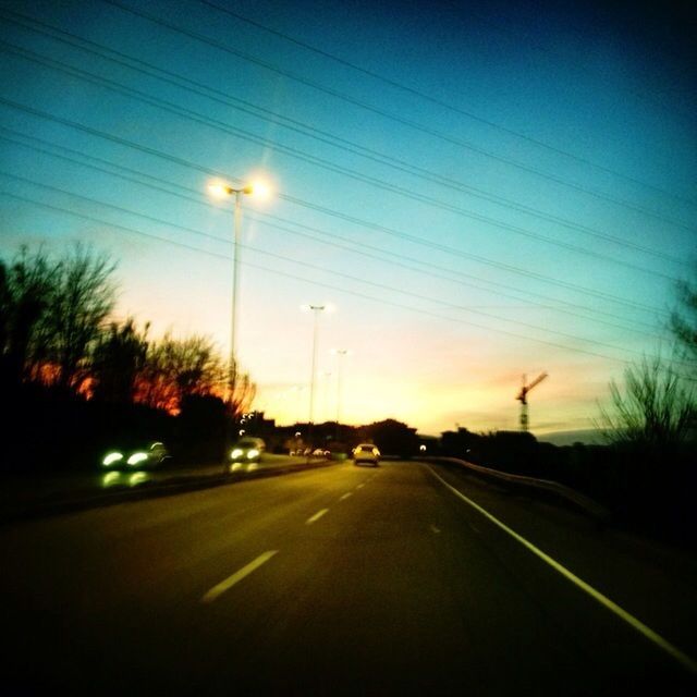 transportation, road, the way forward, diminishing perspective, road marking, sky, street light, silhouette, sunset, car, vanishing point, street, tree, illuminated, electricity pylon, dusk, country road, empty, power line, land vehicle