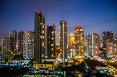 Illuminated buildings in city against sky at night