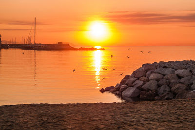 Scenic view of sea against orange sky