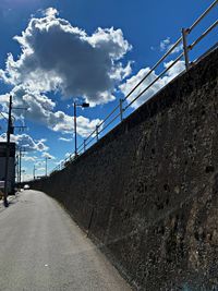 Road by railing against sky
