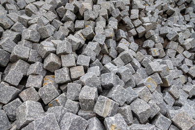 Close up of a pile of loose paving stones before being set into a road paved with setts