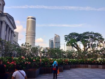 Rear view of woman in city against sky