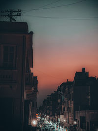 Illuminated buildings against sky at sunset