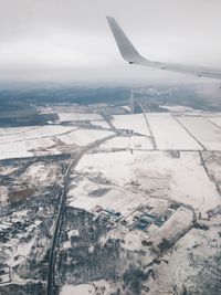 Aerial view of snowcapped landscape against sky during winter