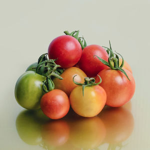 Close-up of tomatoes on table against white background