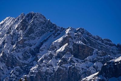 Scenic view of snowcapped mountains against clear blue sky