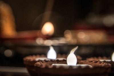 Close-up of lit candles in building