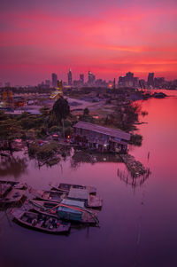 Aerial view of lake and buildings against sky during sunset