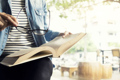 Low section of woman reading book