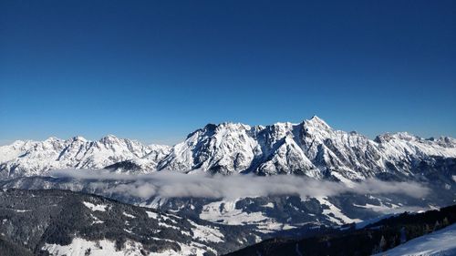 Scenic view of snowcapped mountains against clear blue sky