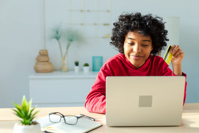 Portrait of woman using laptop at table