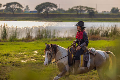 Cowboy's way of life include riding a horse around locales.