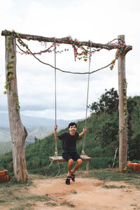 Portrait of man on swing at playground