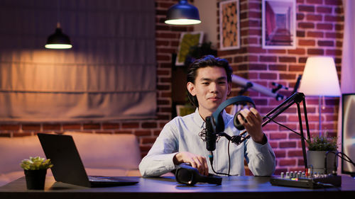 Smiling man holding headphones at recording studio