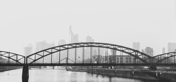 Bridge over river against the skyscrapers in the background