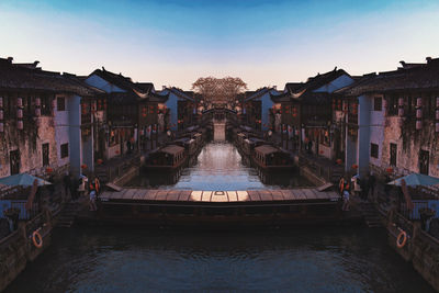 Canal amidst buildings in city against sky