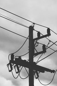 Low angle view of silhouette electricity pylon against sky