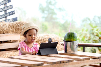 Girl looking away while sitting on table