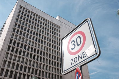 Low angle view of speed limit sign against building in city