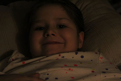 Close-up portrait of boy on bed at home