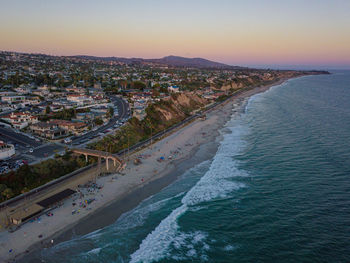 High angle view of sea and buildings against sky during sunset