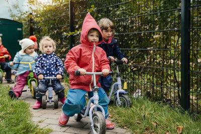 Children using scooters in garden of a kindergarten