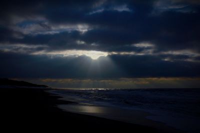 Scenic view of beach against cloudy sky